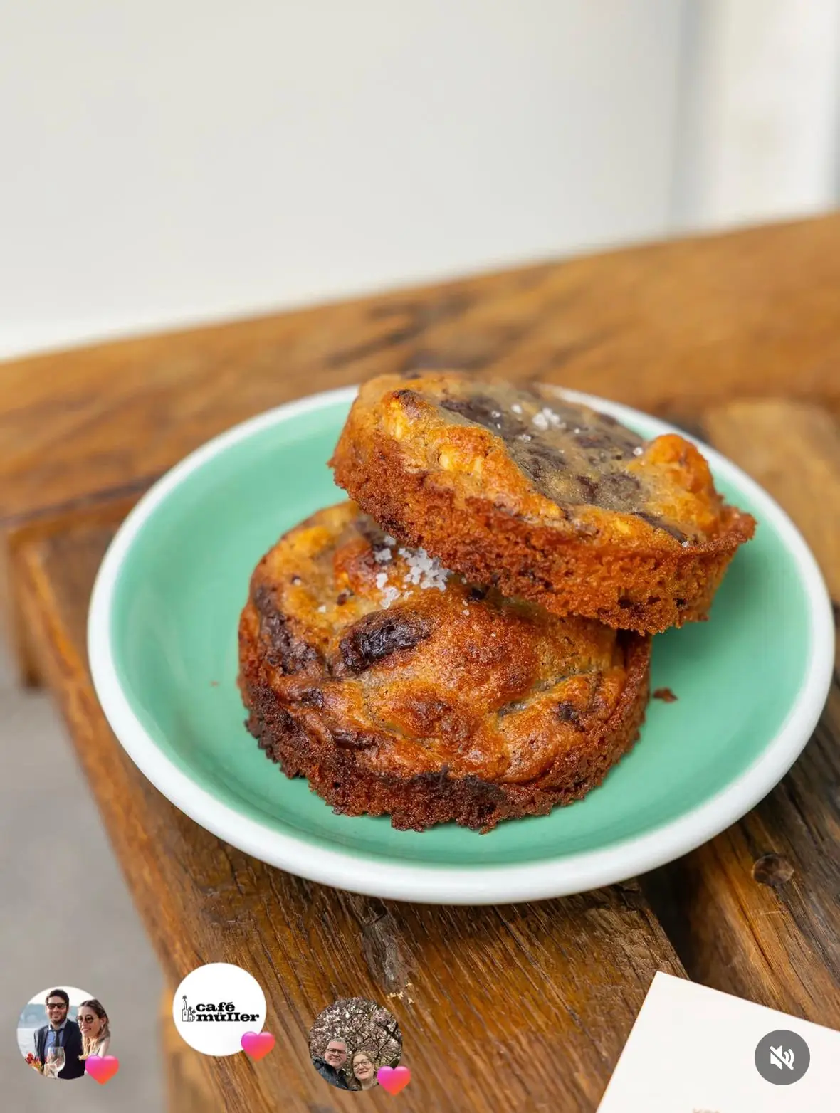 Two chocolate cookies with sea salt on a green plate